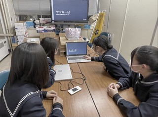 写真：PCのディスプレイを見る学生たち