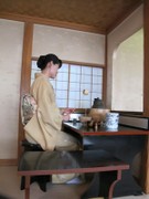 椅子席の茶席でお茶のお点前をする着物の人の様子
