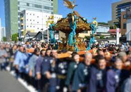 大勢の人で神輿を担いている写真