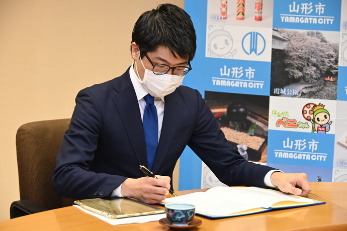 株式会社TRAPEの代表取締役の鎌田様が協定書にサインをしています