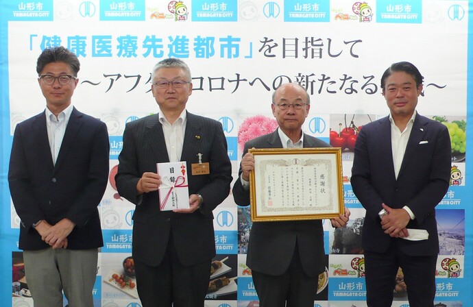 寄附贈呈式の写真です。左からきらやか銀行鈴木執行役員部長、金沢教育長、特定非営利活動法人CoCoLo吉國副理事長、株式会社ウエストエネルギーソリューション池田取締役です。