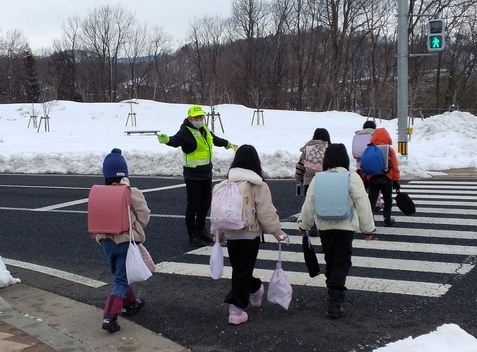 子ども達が安全に登下校できるよう町内会で立哨指導している様子の写真