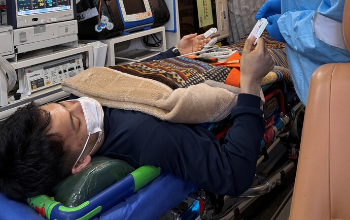 救急車内で患者にマイナ保険証の受け取りの同意を得ている写真
