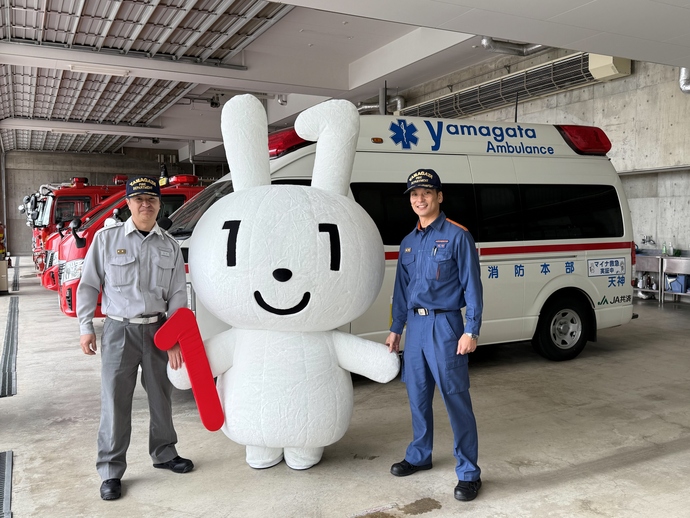 救急車の前で消防職員2人とマイナちゃんの写真