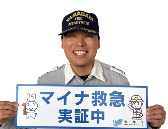 消防職員が「マイナ救急実証中」とかいてあるカードを持っている写真