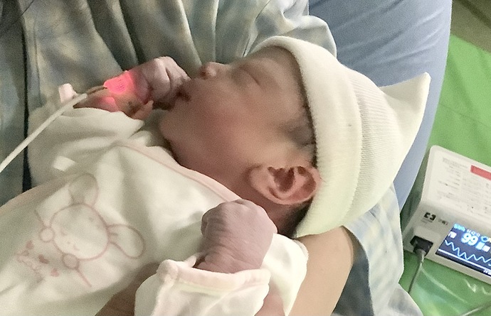 産後抱きかかえられる赤ちゃん